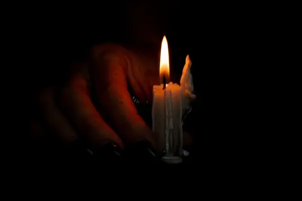 صورة تحتوي على شمعة و يد تحملها اقوى شيخ لفك السحر
